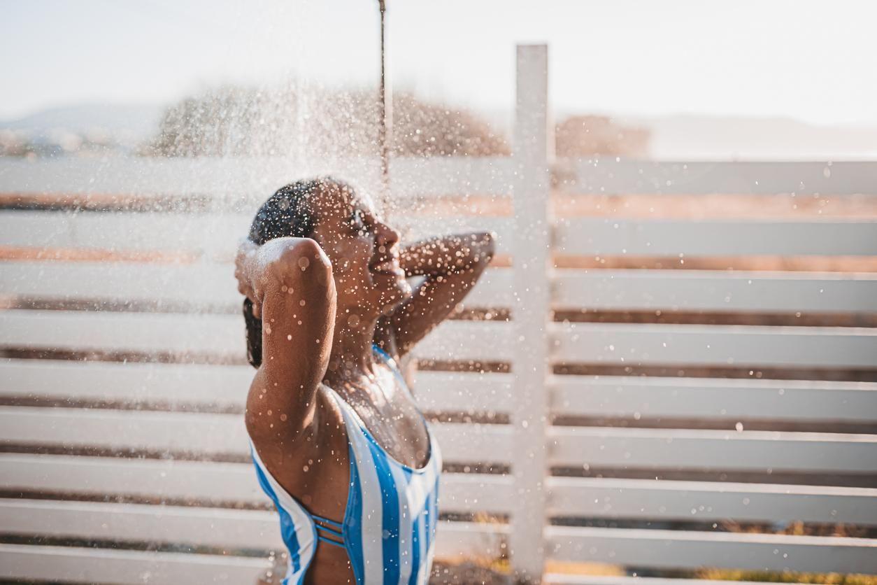Woman showering on the beach.