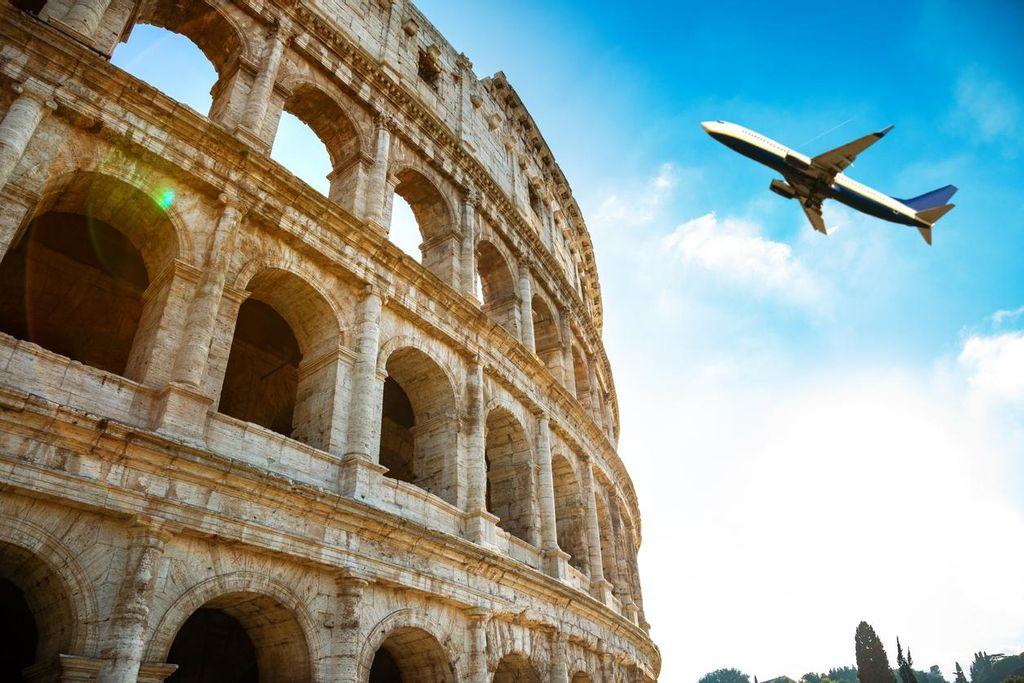 Airplane flying over the Colosseum in Rome.