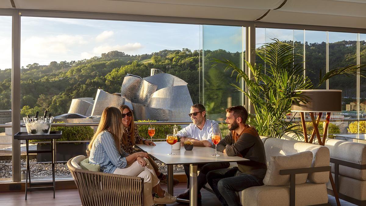 A toast at sunset on The Rooftop, with the Guggenheim in the background